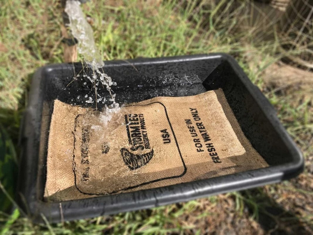 Stormbag – sac anti-inondation haute performance, remplissant une trappe en profondeur avec de l’eau qui s’écoule dans le bac noir.