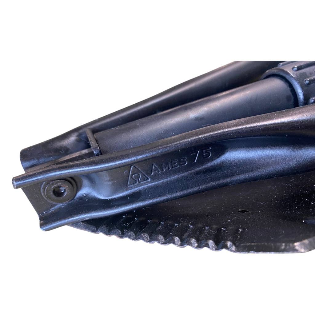 Sangle et pliage d’un couteau ou outil pliant avec marquage AMES 7/5 sur le métal noir.