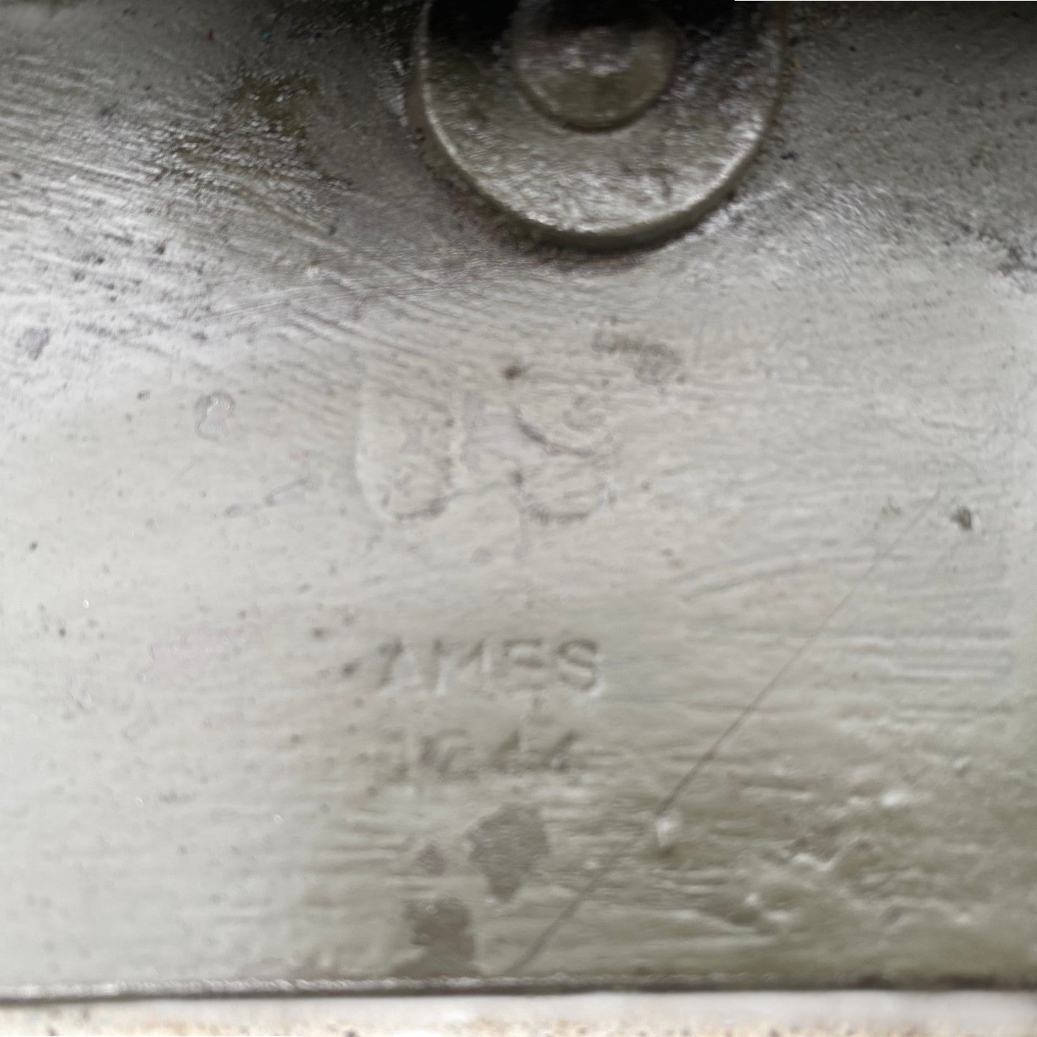 AL̀T: Gravure et marquages sur une plaque métallique: logo U.S. Army et texte "TMS" ou "TM S" légèrement visibles, surface usée et patinée. Pelle WW2 US Army 1944 originale authentique.