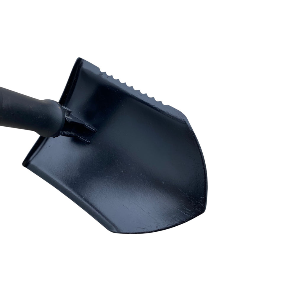 Pelle pliante noire avec lame métallique et dents rugueuses, poignée étroite et jointure à la base.